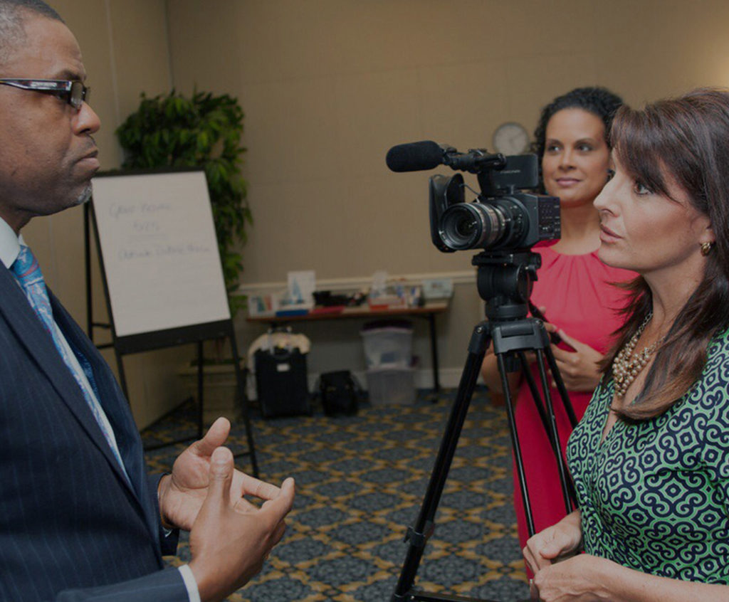 Employee interviewing with video camera in the background