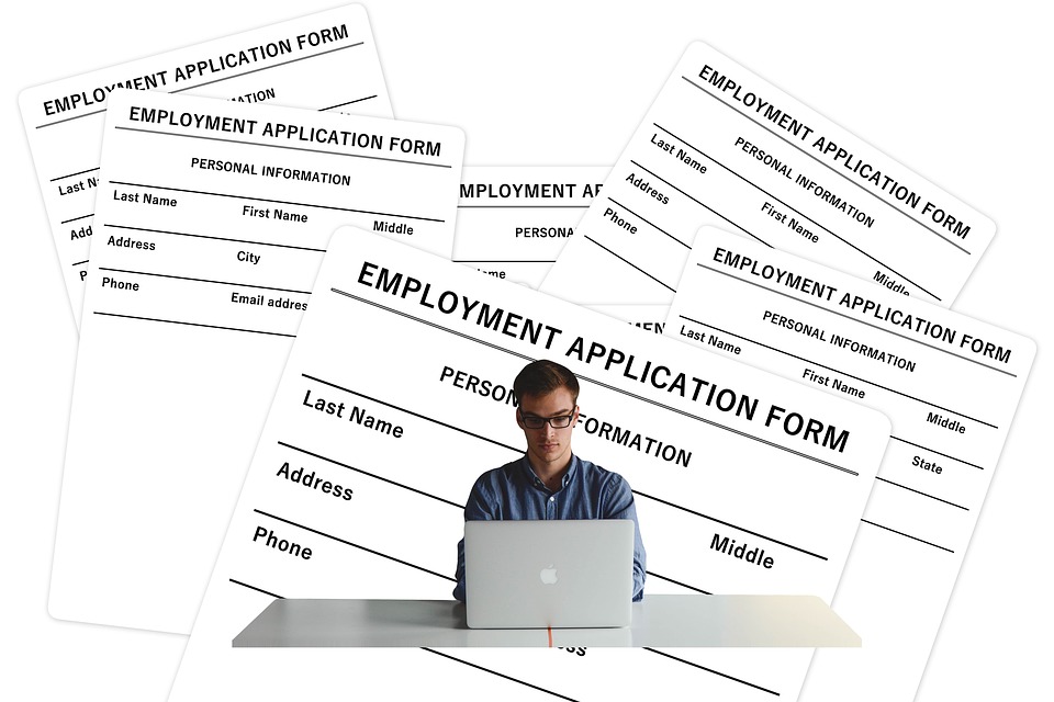 HR forms surrounding man on computer